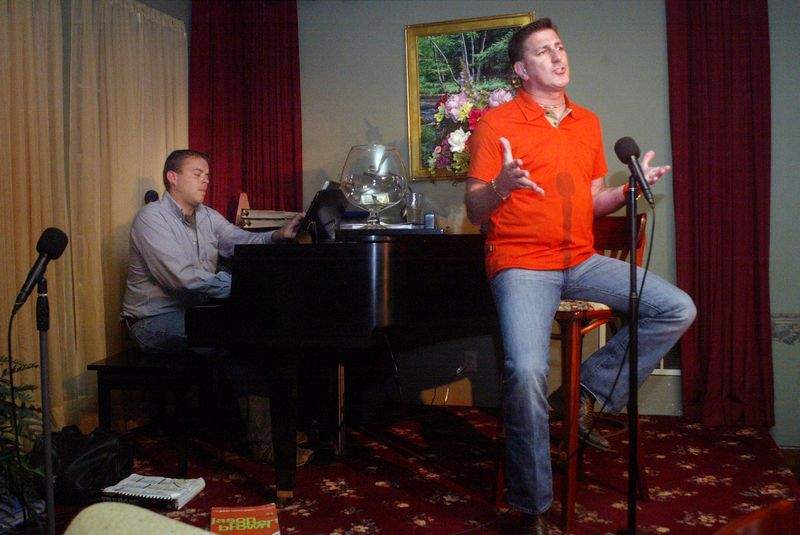 two men giving a musical performance with piano and vocals
